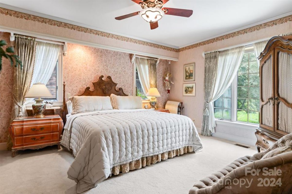 Bedroom with a carved wooden headboard and plush bedding.