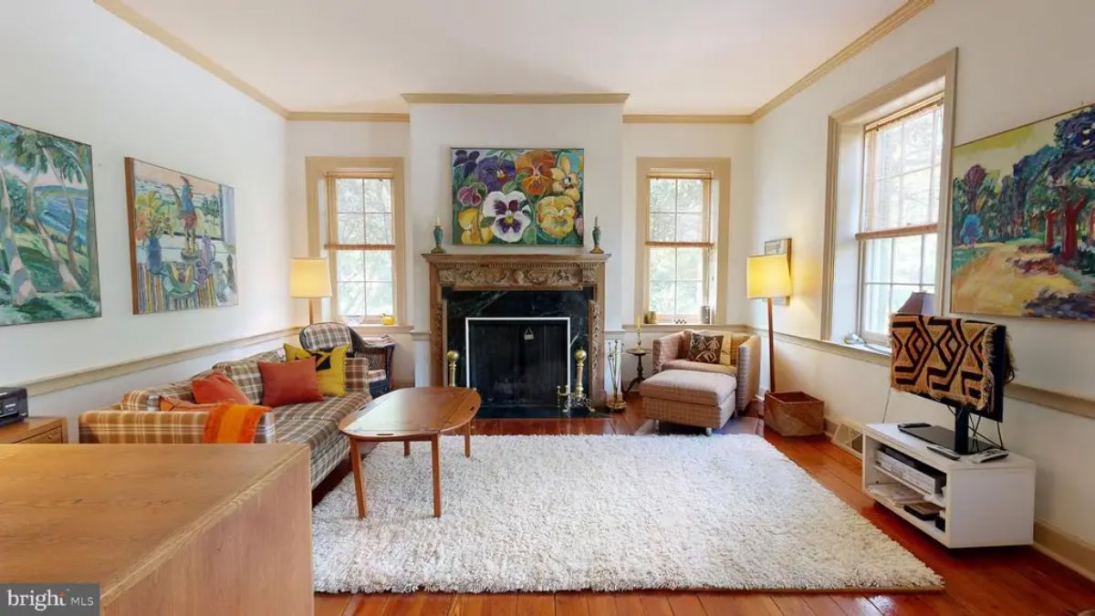 Living room features a beautifully detailed fireplace mantel with a dark marble surround as the focal point.