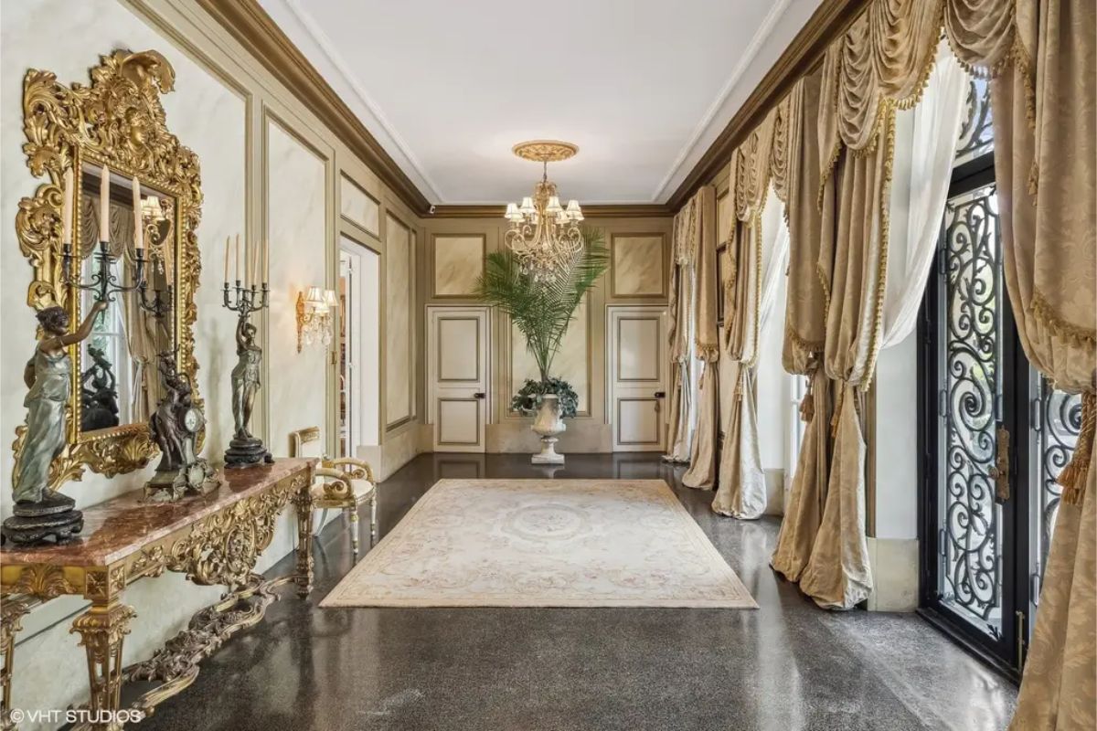 Gilded mirrors and intricate gold detailing define the decor, accompanied by a marble console table.