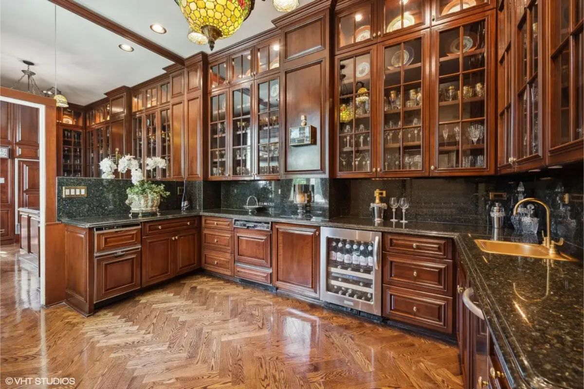 Dark wood cabinetry with glass-front doors showcases elegant dishware and crystal.