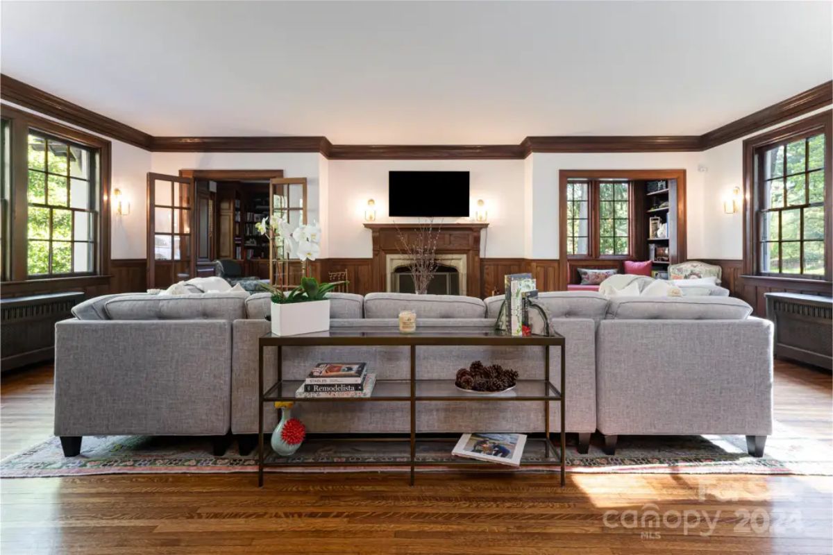 A central fireplace with a wooden mantel, flanked by built-in shelving.