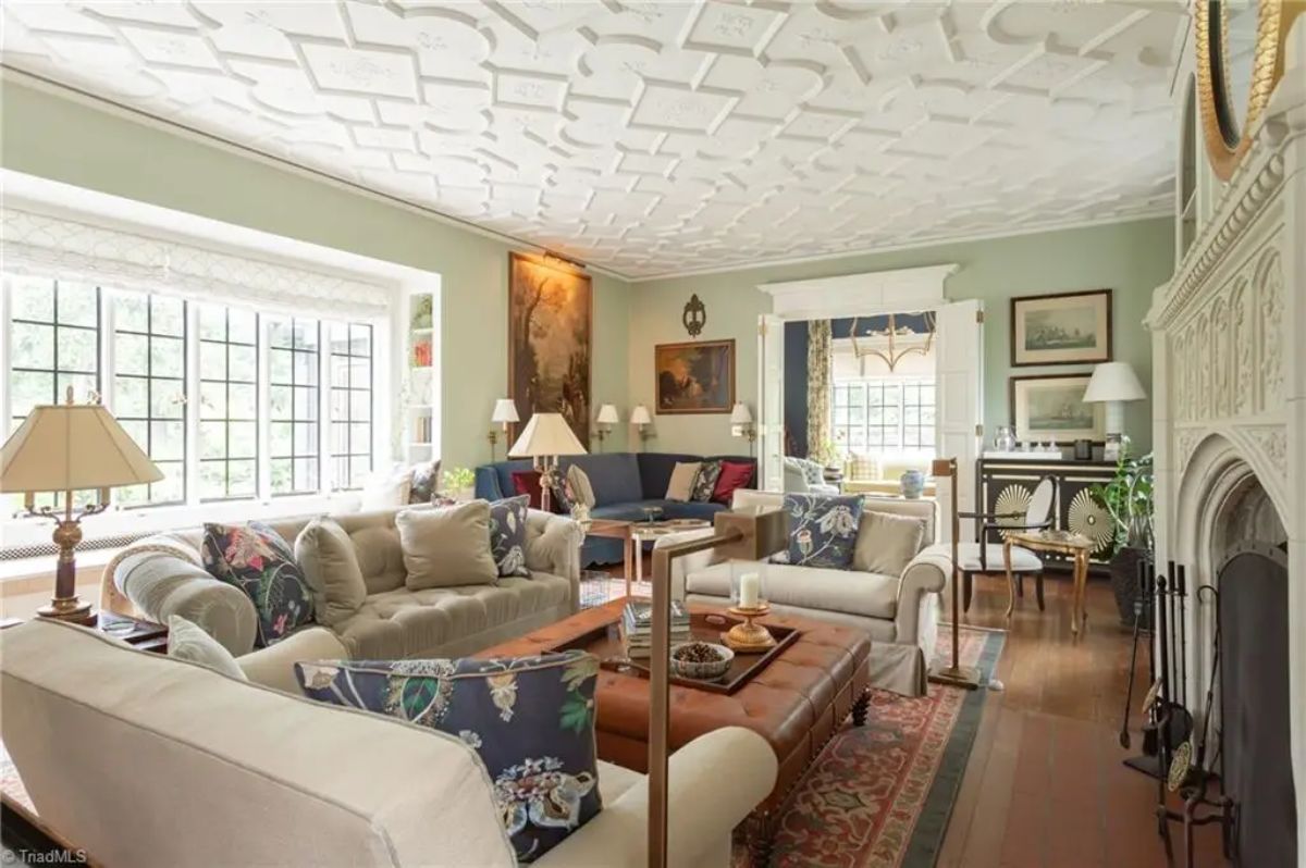 Living room is decorated with light neutral furniture accented by floral and patterned throw pillows.