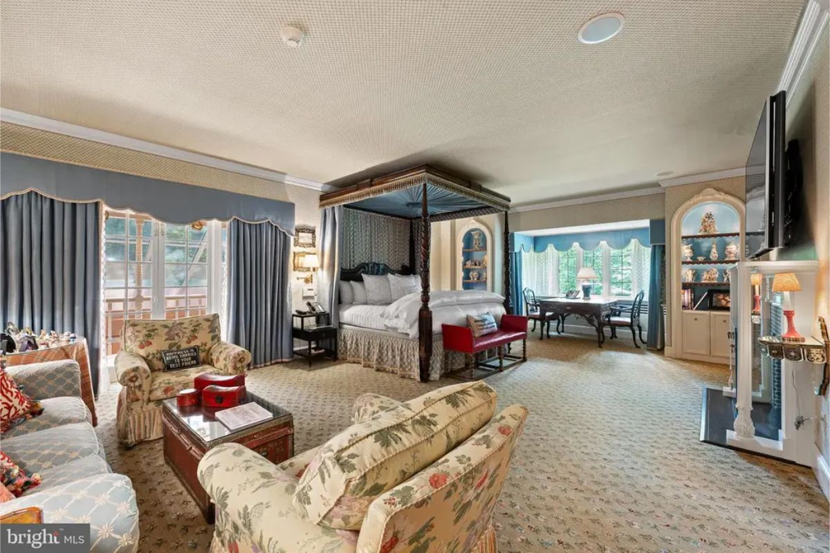 Bedroom includes a four-poster bed and ample seating, creating a cozy and functional space.