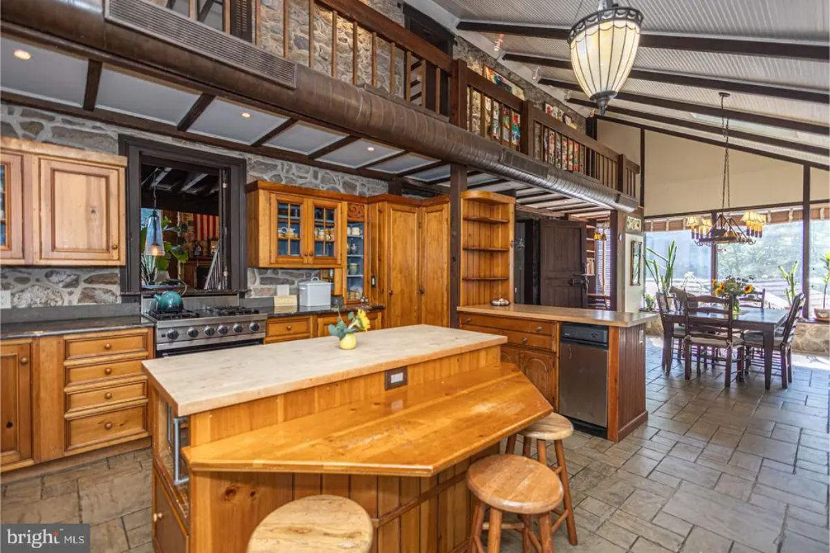 Wooden cabinetry and stone walls create a warm and functional cooking space.