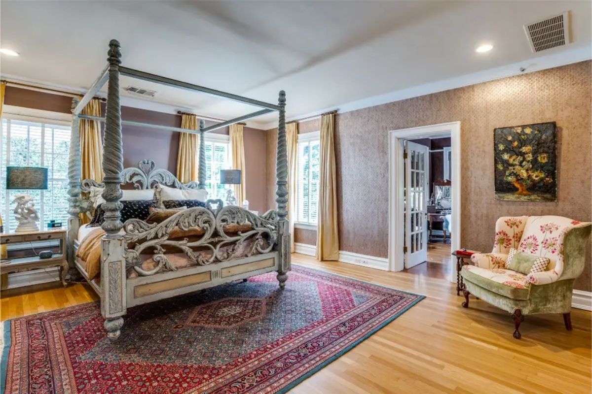 Large bedroom with an intricately carved four-poster bed as the centerpiece.