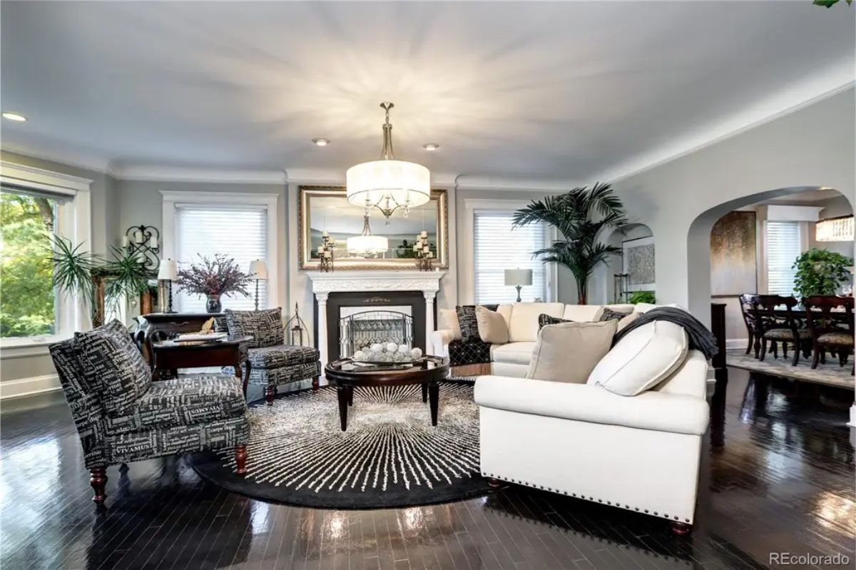 Living room features a beautifully designed fireplace as its focal point, flanked by large windows that flood the space with natural light.