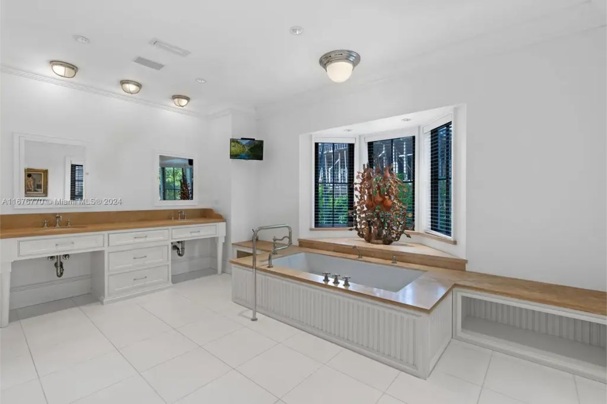 Bathroom with a built-in soaking tub surrounded by wooden countertops and shelving.