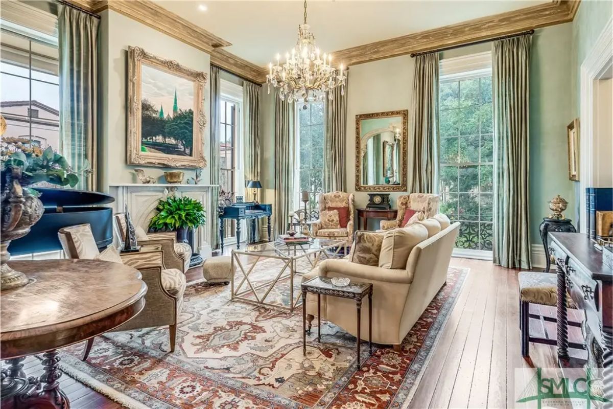 Large windows with flowing drapes bring natural light into this refined living space.