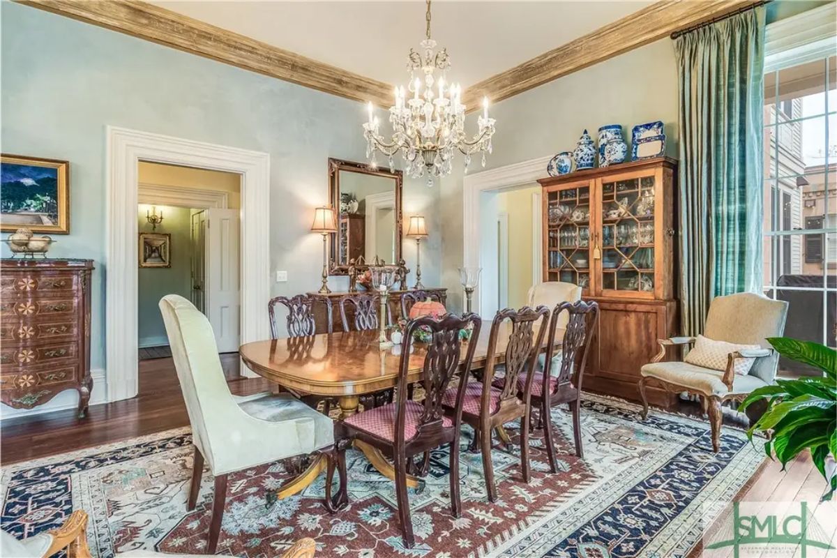 Polished wooden table surrounded by intricately carved chairs.