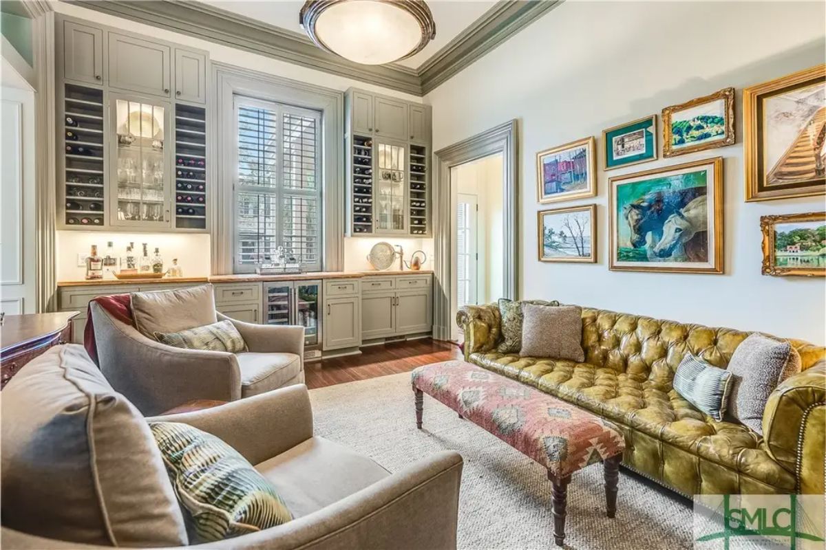 Built-in cabinetry surrounds a central window with wine storage and a bar area.