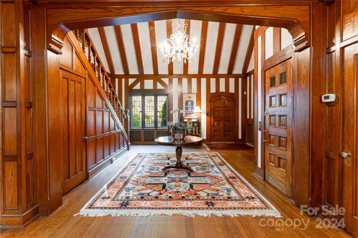 Entryway showcases rich wood paneling and beams, paired with a vaulted ceiling for a dramatic architectural effect.