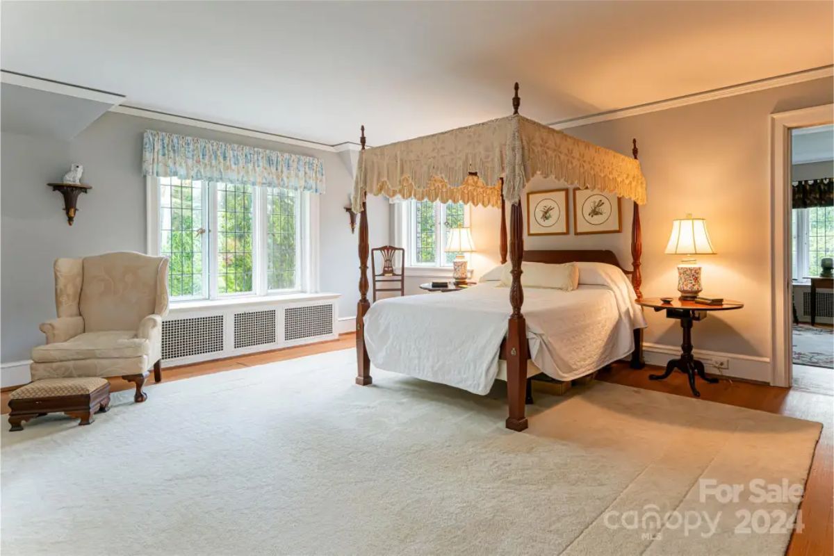 Bedroom is centered around a four-poster canopy bed with intricate lace detailing.