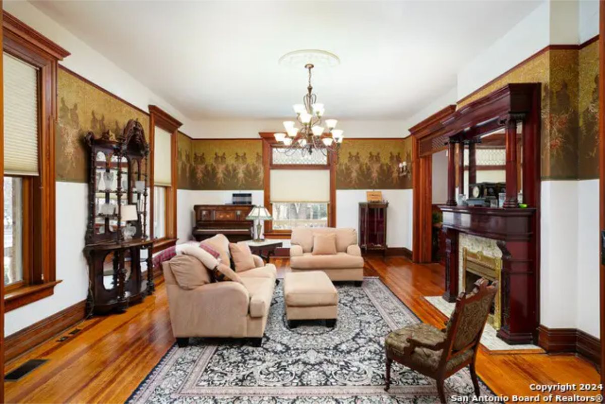 Living area featuring intricate wallpaper and rich wood detailing.