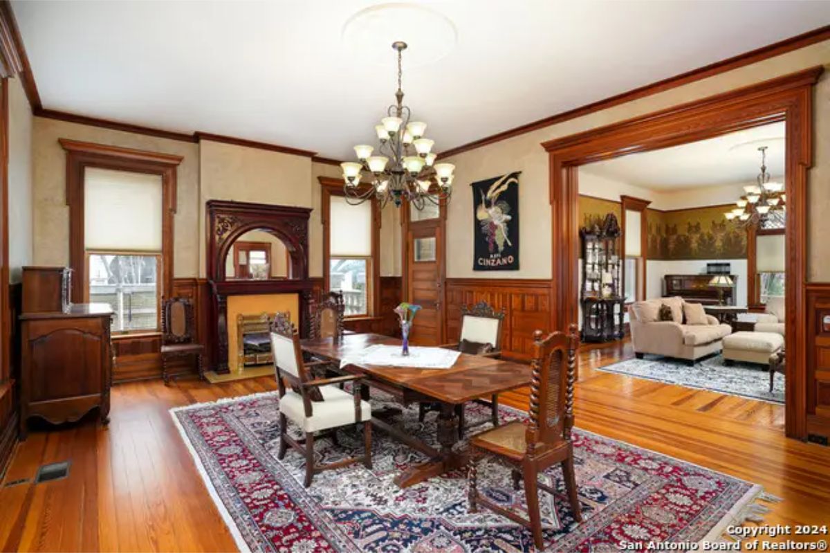 Dining room showcasing intricate wood paneling and a decorative fireplace.