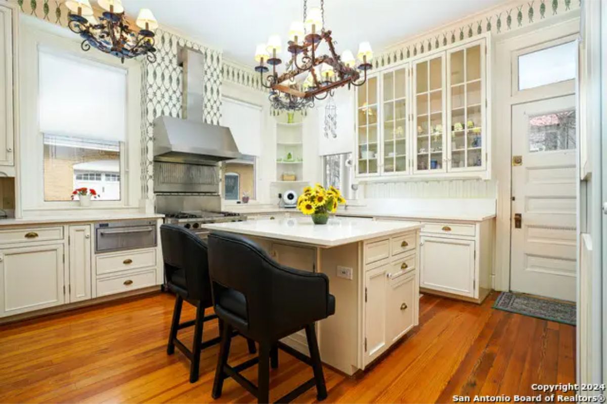 Kitchen with white cabinetry and glass-front storage.