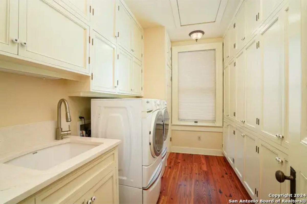 Laundry room with built-in cabinets lining the walls for ample storage.