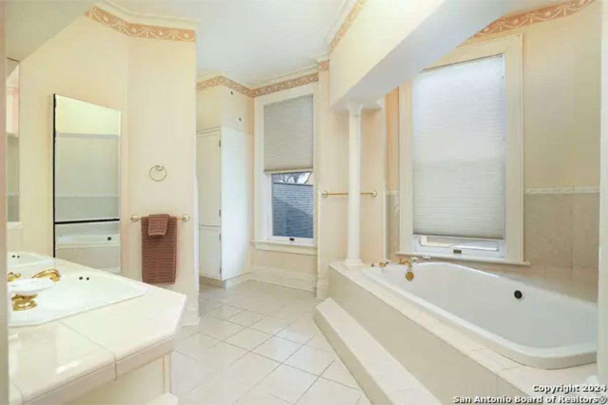 Bathroom with a built-in soaking tub framed by columns and steps.