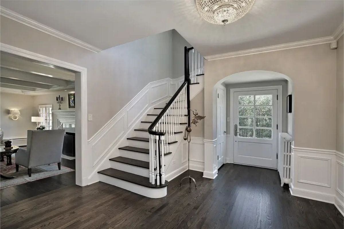 Curved staircase with dark wood steps and white risers, accented by a black handrail.