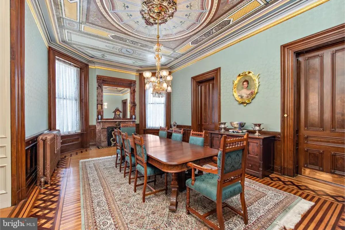 Dining room highlights intricate parquet flooring and richly carved wooden doors and wainscoting.