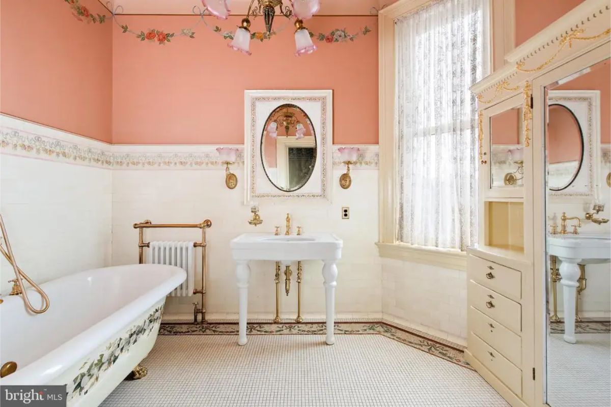 A clawfoot bathtub with floral detailing and brass fixtures.