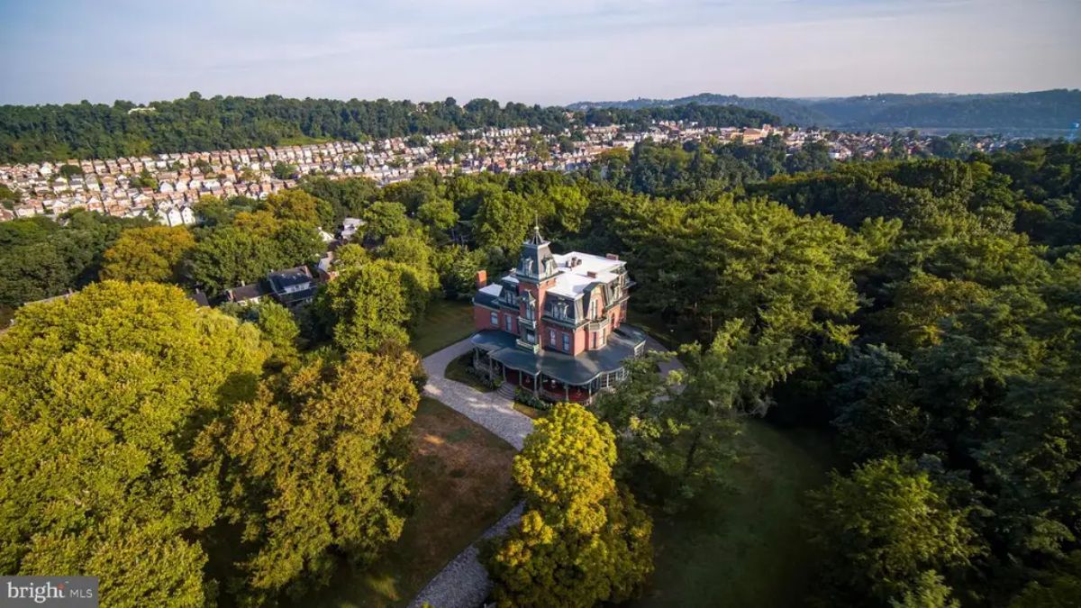 Victorian-era mansion is situated on a 1.8-acre lot surrounded by lush greenery and parkland.