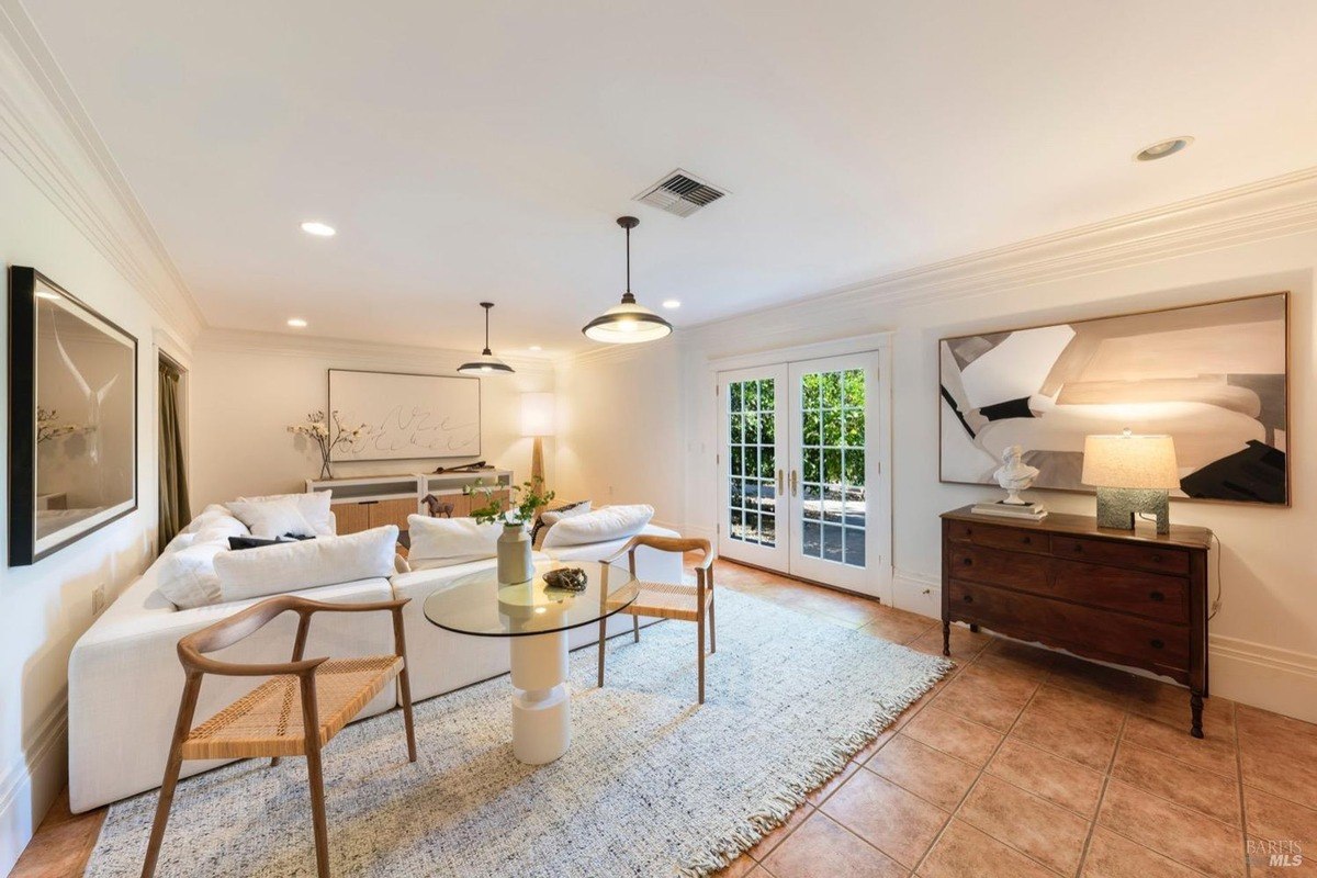 Family room with a large white sectional sofa, a glass coffee table, and access to a patio.