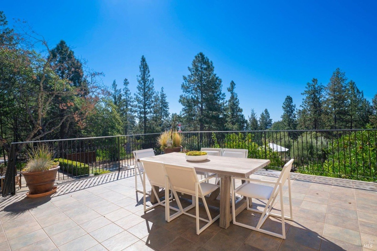 Outdoor dining area with a large table and chairs, while taking in the surrounding natural beauty.