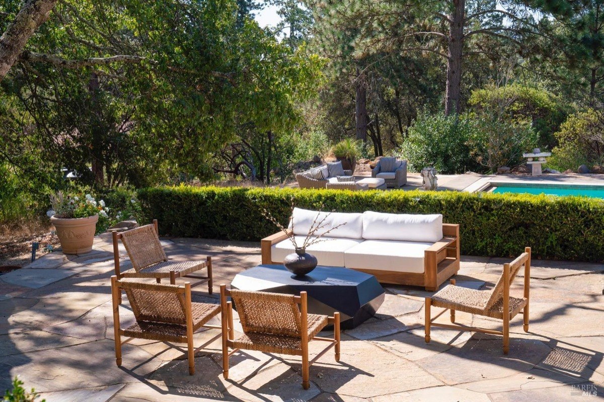 Luxurious outdoor oasis with a sparkling pool, lush landscaping, and a spacious patio.