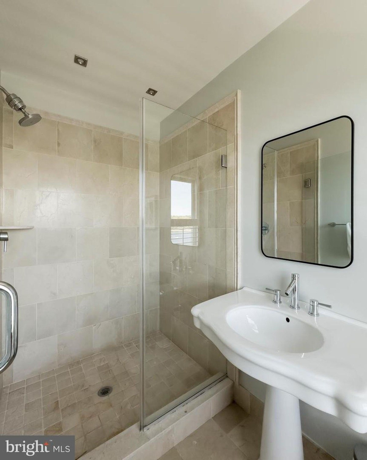 Bathroom has a shower, pedestal sink, and a small window.