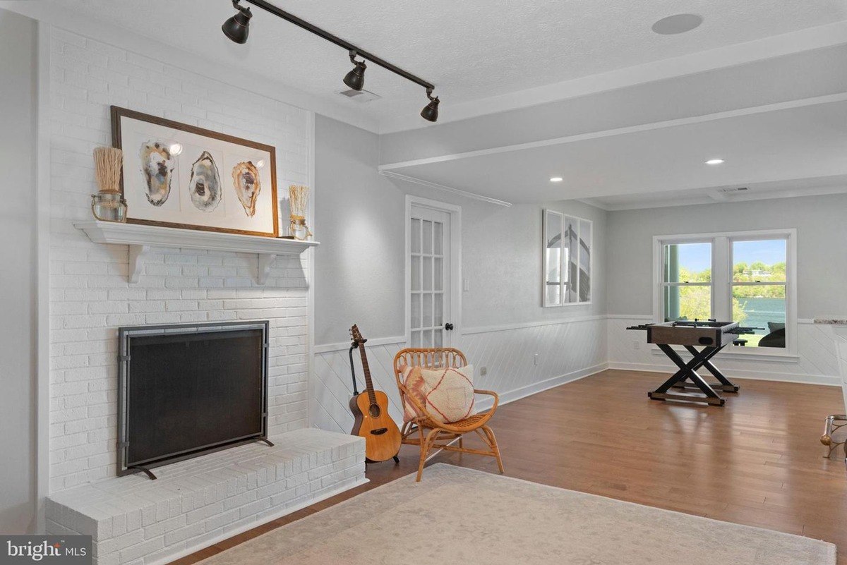 Game room has a foosball table, fireplace, and hardwood floors.