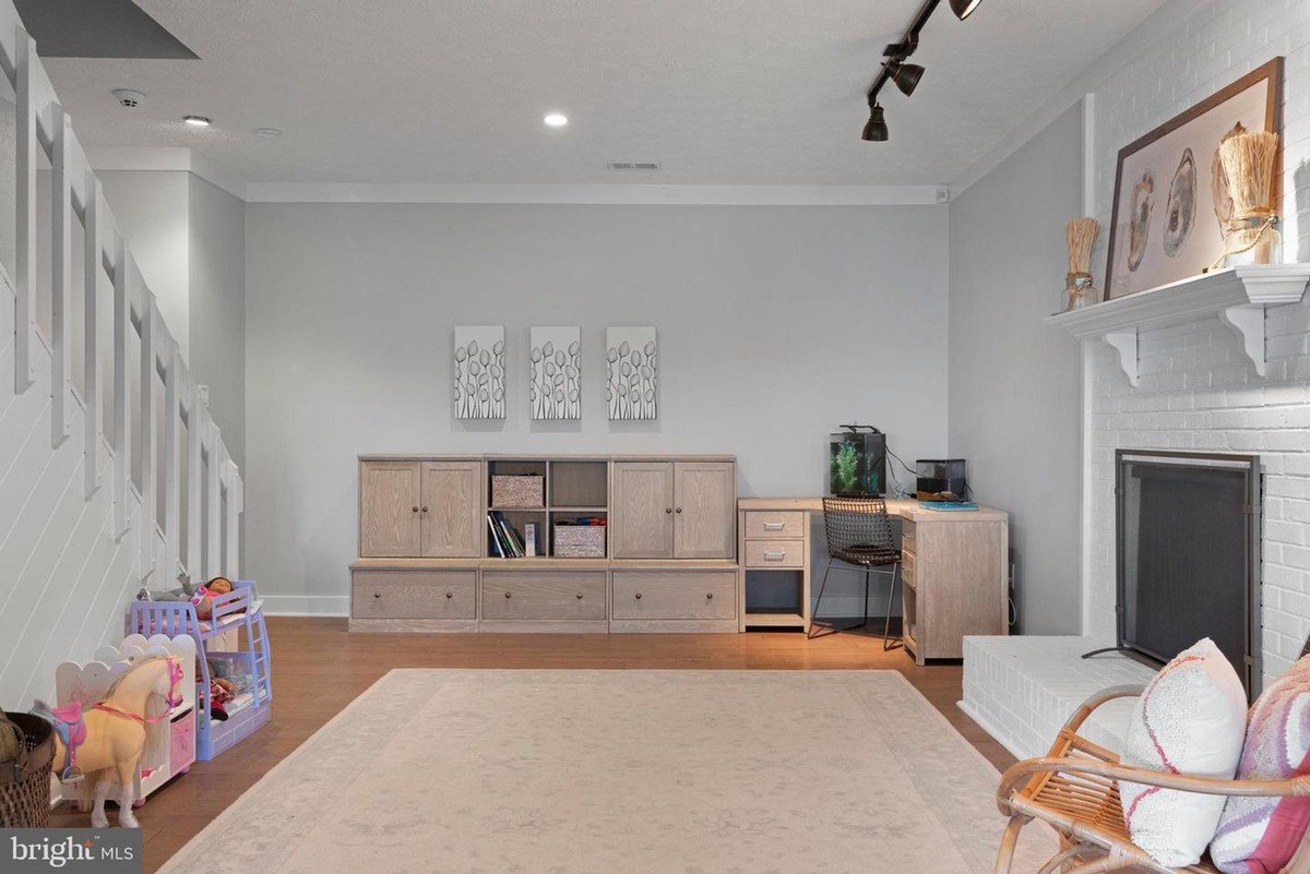 Playroom has a large beige cabinet, desk, and area rug.