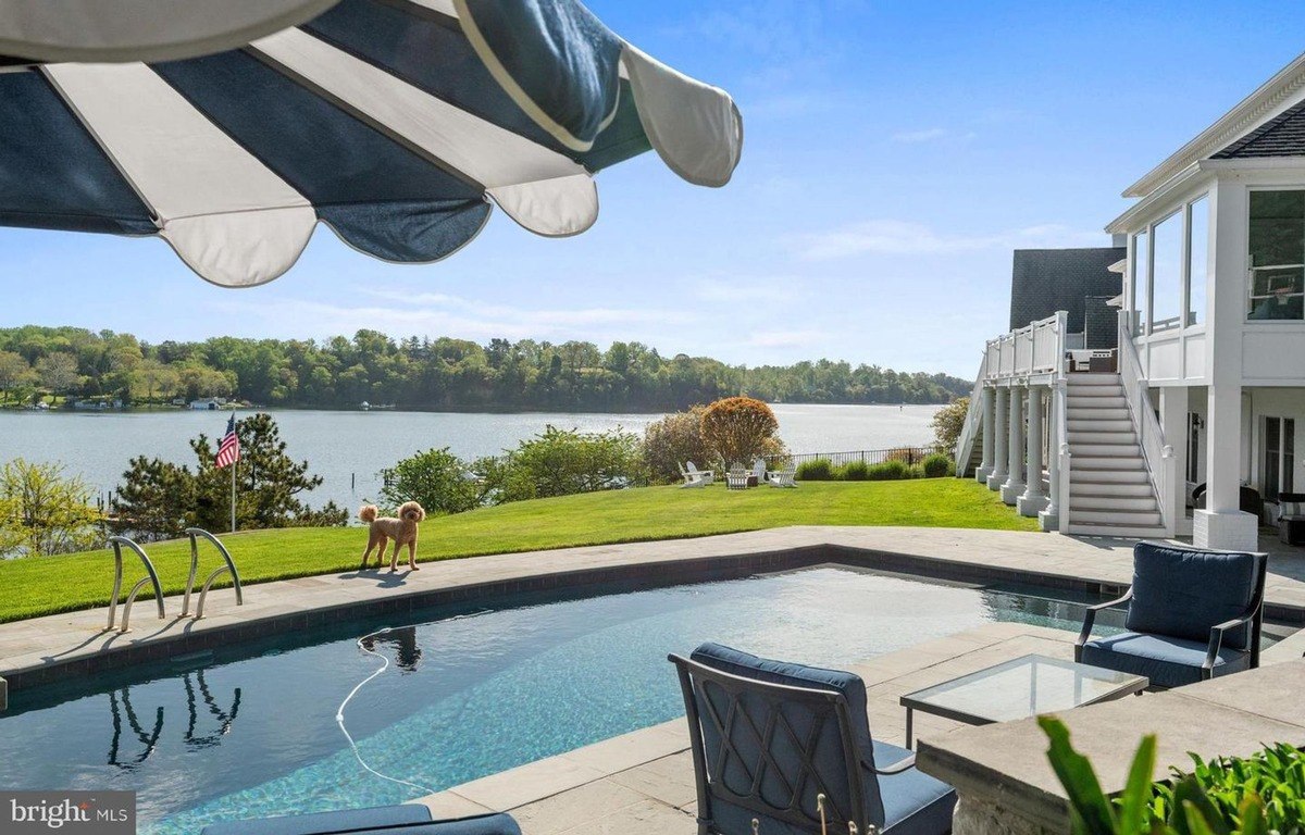 Pool area has a swimming pool, patio furniture, and a view of water.