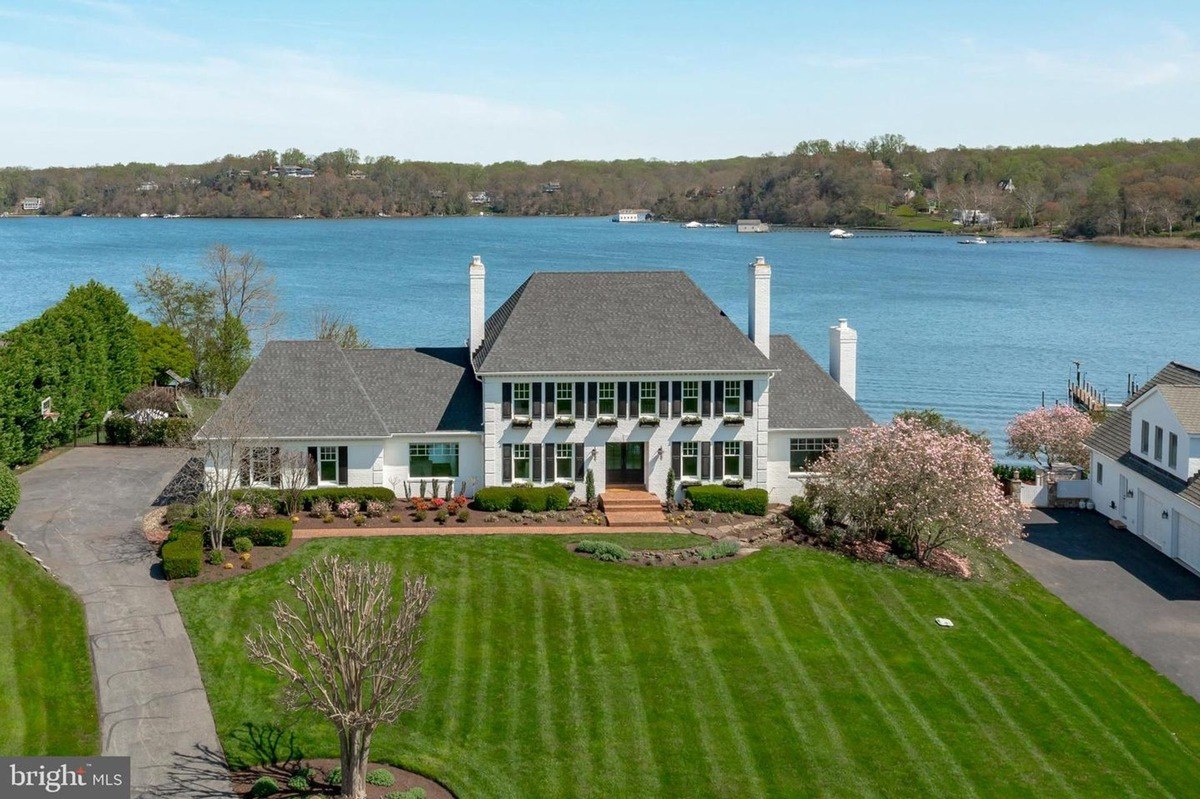 House is white with black shutters and has a water view.