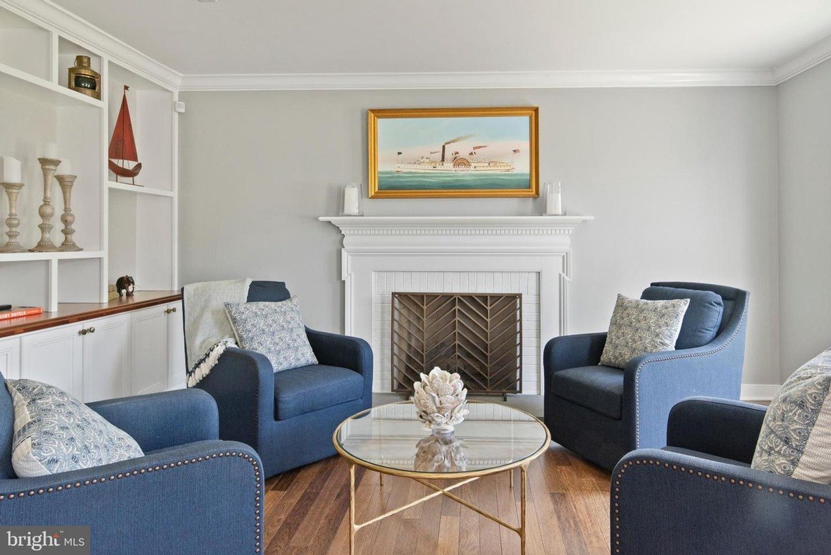 Living room has blue armchairs, a fireplace, and built-in shelving.