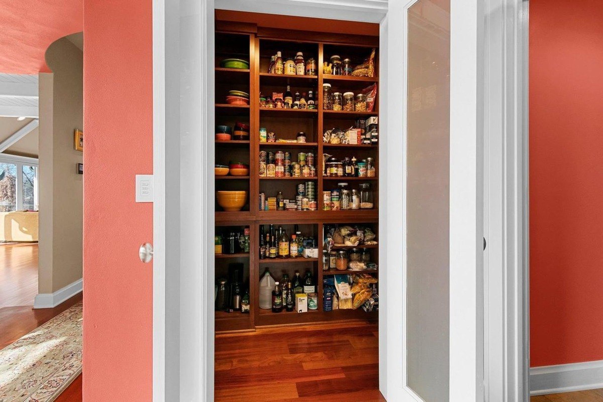 Wooden pantry shelves stocked with food and supplies.