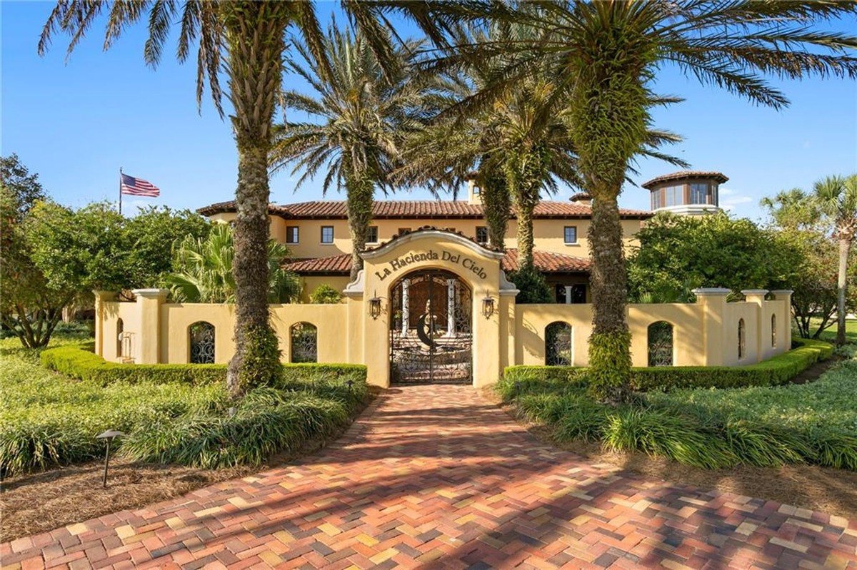 Grand estate boasts a Mediterranean-style home with a central fountain and palm trees.