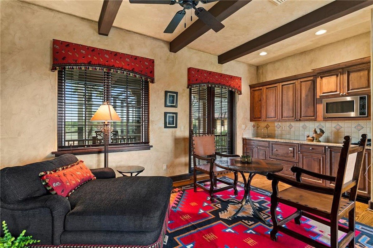 A cozy retreat with a rustic charm, this intimate sitting area features a plush chaise lounge and a vibrant Southwestern-inspired rug, inviting relaxation and contemplation.