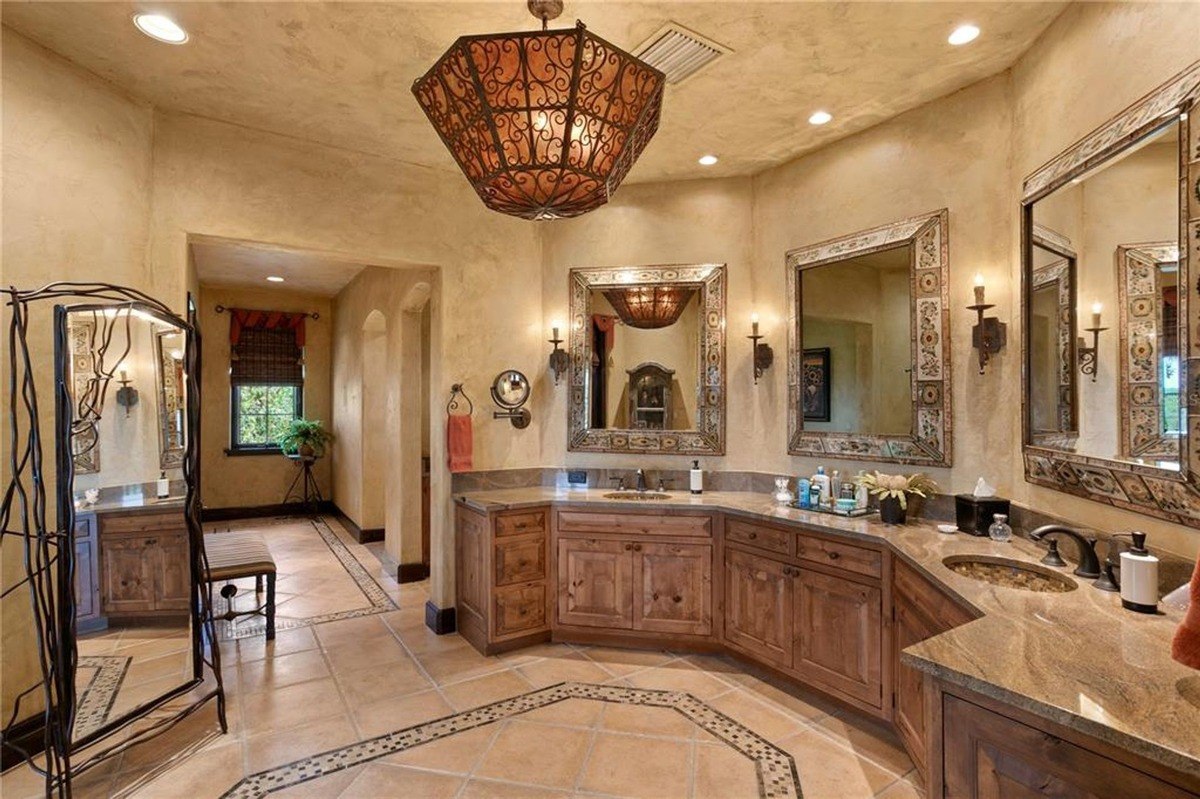 Bathroom features a large vanity with double sinks, ornate mirrors, and a rustic chandelier.