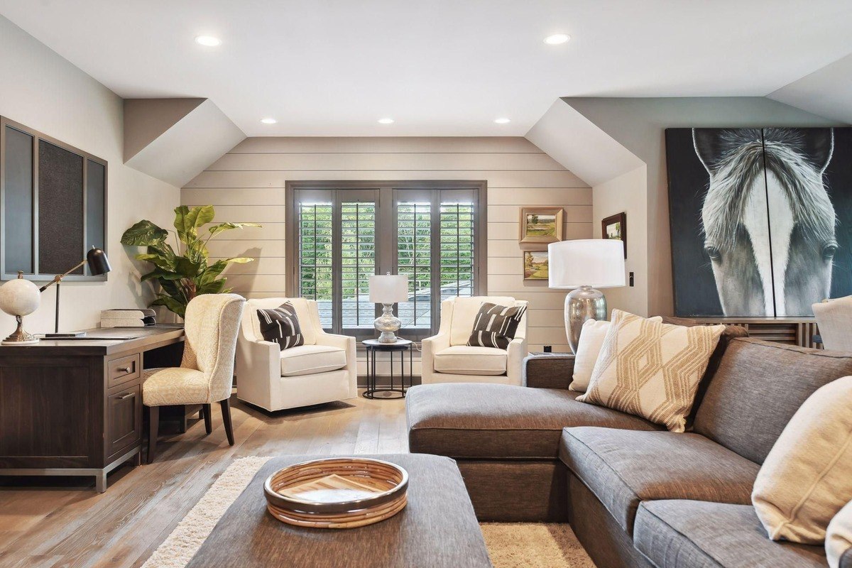 Office and sitting room a bright office space with an upholstered sectional, shiplap walls, and large artwork.