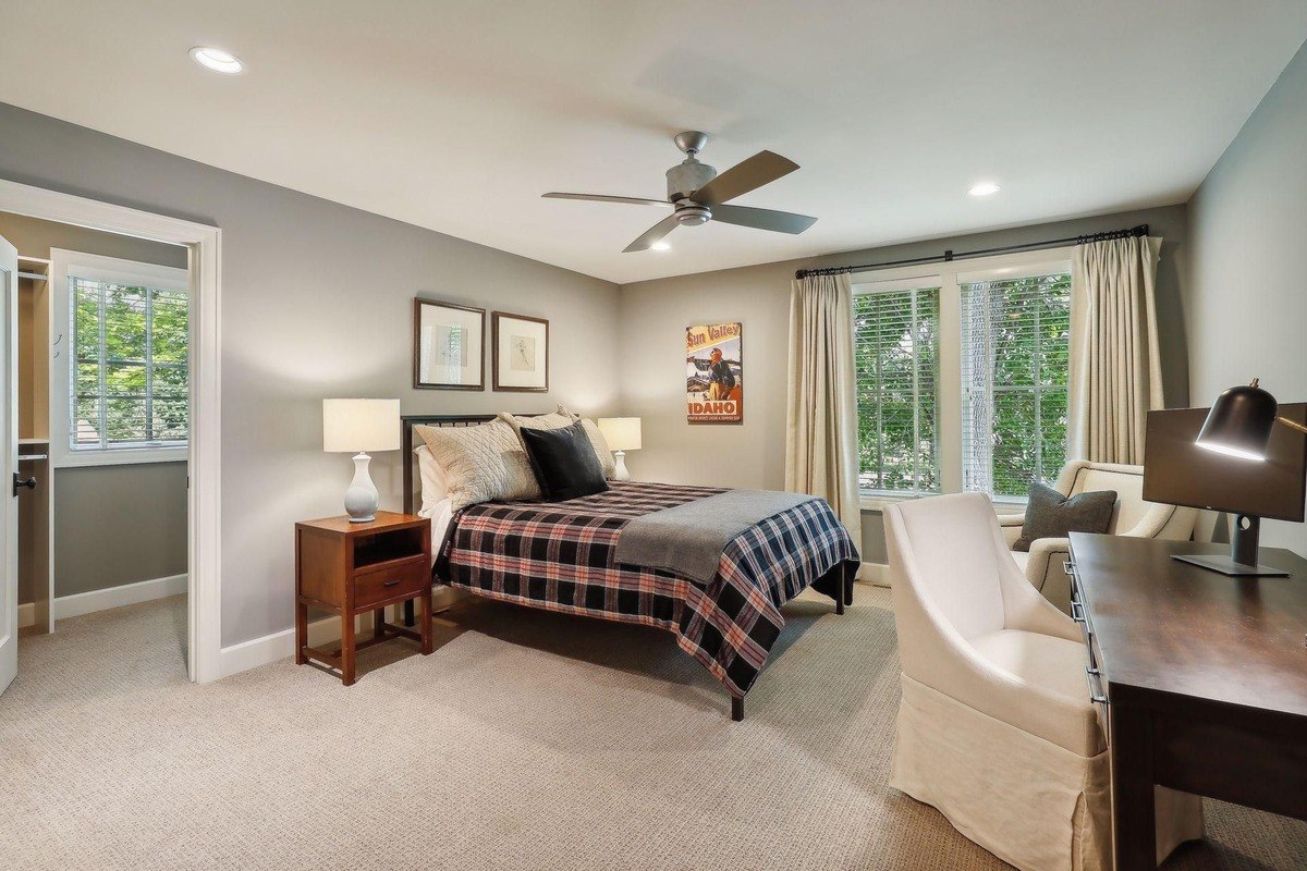 Spacious bedroom with a large bed, study desk, and a neutral color palette.