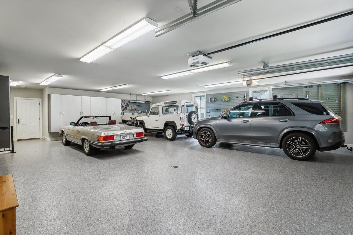 Large garage with multiple cars parked and built-in storage units.