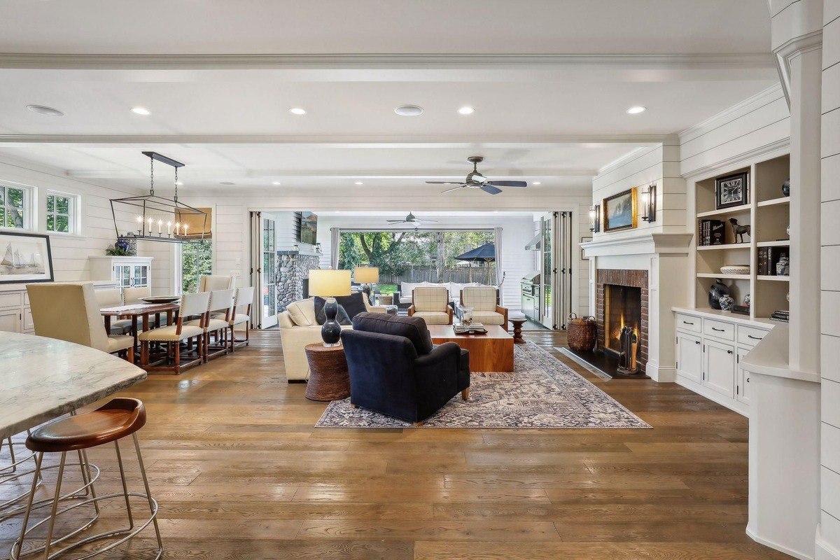 Open-concept living room a spacious room featuring built-in shelves, a fireplace, and large sliding doors opening to the outdoor area.