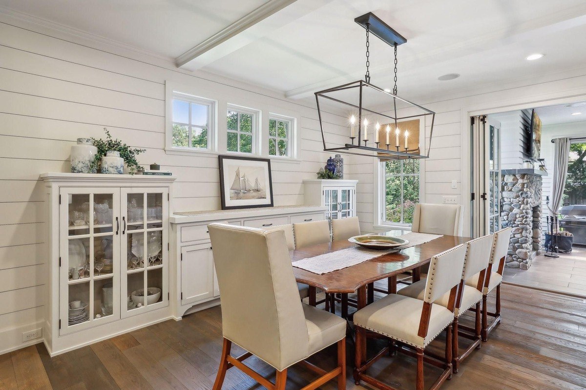 Dining area a dining space with a long wooden table, cream chairs, and a view of the backyard.