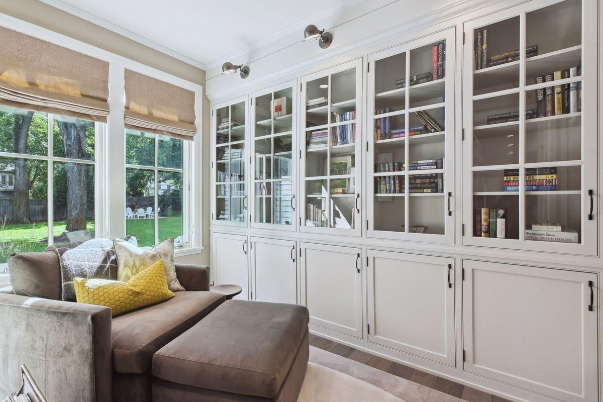 Reading nook a library area with large windows, built-in bookshelves, and a comfortable chaise lounge.