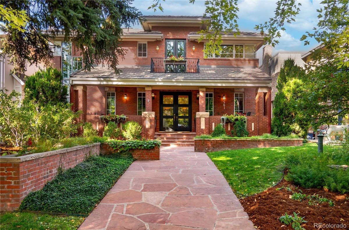 Stone walkway and carefully planned landscaping complement the brick house.