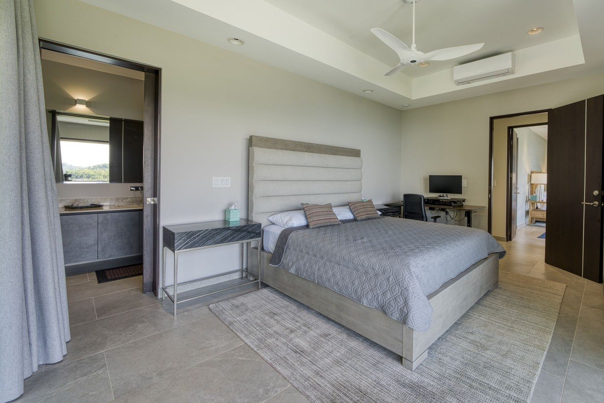 Bedroom has king-size bed, ceiling fan, and attached bathroom.