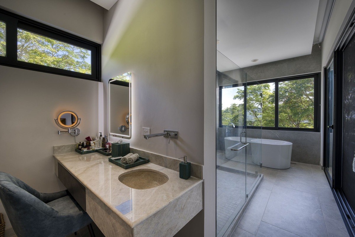 Bathroom has double vanity, large mirror, and freestanding bathtub.