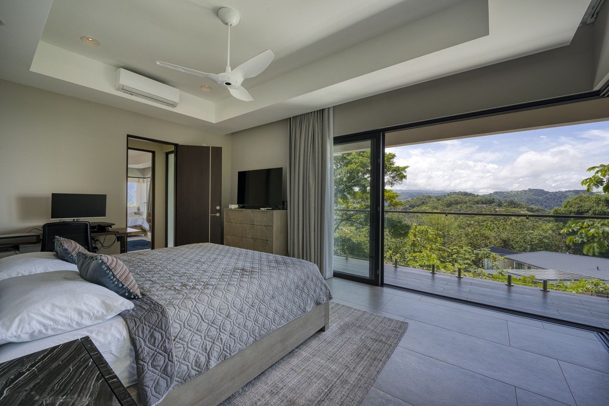 Bedroom has king-size bed, ceiling fan, and view of mountains.