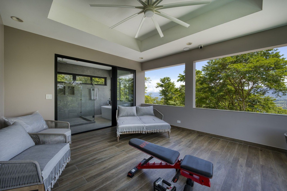 Patio has seating, weight bench, and views of trees and ocean.