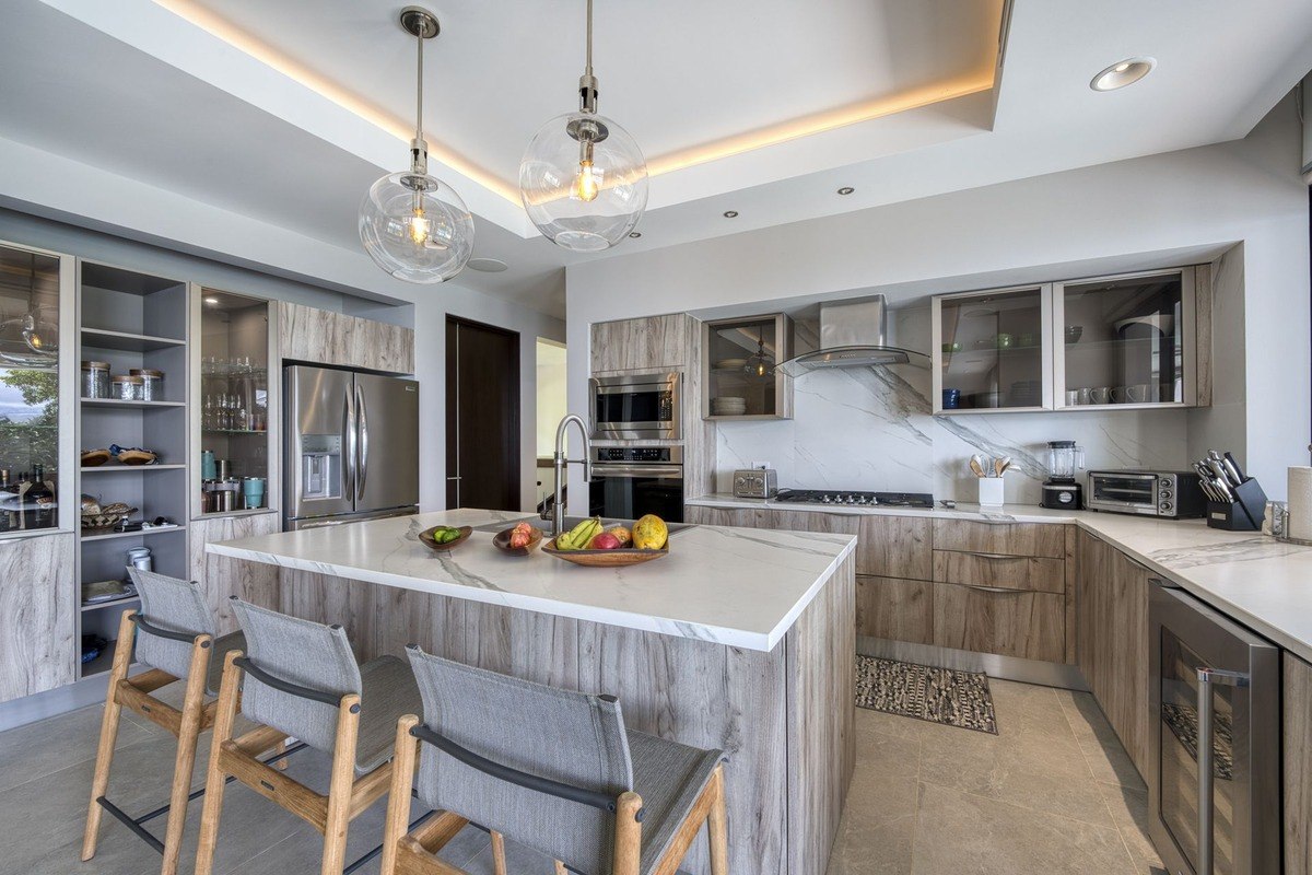 Kitchen has island with seating, wood cabinets, and stainless steel appliances.